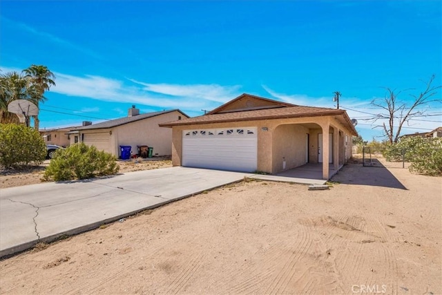 72454 El Paseo Dr Unit 29, Palms, CA 92277 - view of front of property featuring an attached garage, stucco siding, and driveway