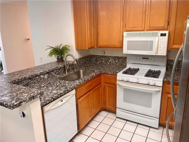 21203 Camelia Unit 34, Lake Forest, CA 92630 - kitchen featuring white appliances, a sink, a peninsula, and dark stone countertops