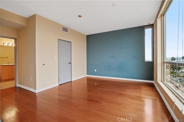 spare room featuring wood finished floors and baseboards