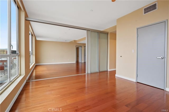 spare room with light wood-type flooring and baseboards