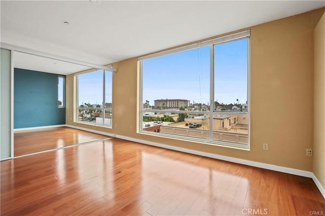 empty room with baseboards and wood finished floors