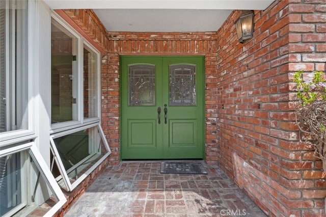 view of exterior entry with brick siding