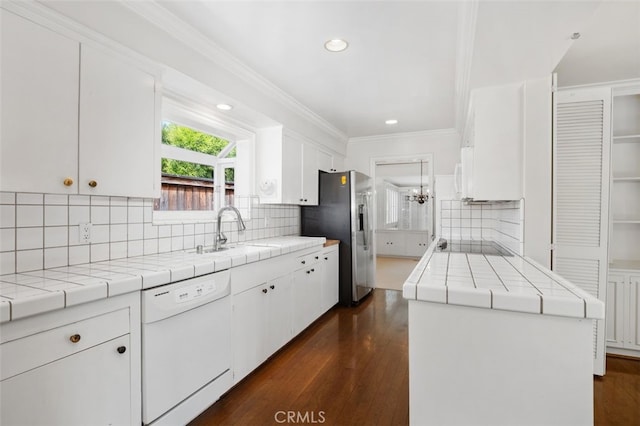 kitchen with white appliances, tile counters, a sink, white cabinets, and recessed lighting