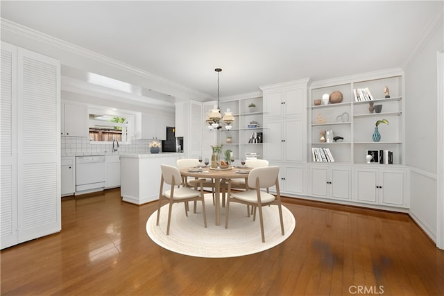 dining area with dark wood finished floors, a chandelier, and crown molding
