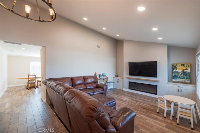 19931 Leecrest Ln, Huntington Beach, CA 92646 - living area featuring wood finished floors, recessed lighting, a glass covered fireplace, a chandelier, and baseboards