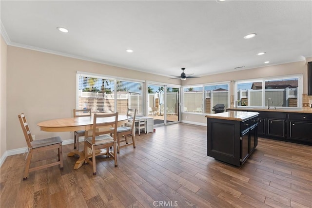 19931 Leecrest Ln, Huntington Beach, CA 92646 - kitchen featuring crown molding, dark cabinetry, baseboards, wood finished floors, and light countertops