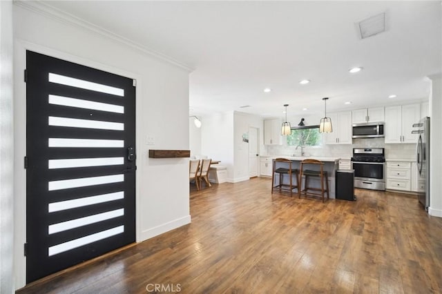 18356 Friar St, Tarzana, CA 91335 - kitchen featuring stainless steel appliances, white cabinets, dark wood finished floors, a kitchen island, and a sink