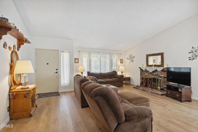 1093 Hickory View Cir, Camarillo, CA 93012 - living room featuring light wood finished floors, vaulted ceiling, baseboards, a textured ceiling, and a brick fireplace