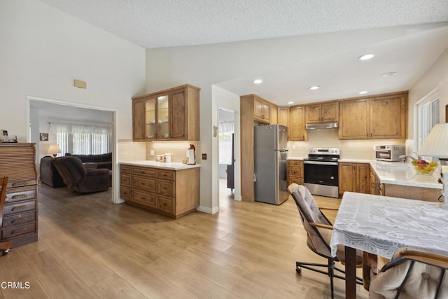 1093 Hickory View Cir, Camarillo, CA 93012 - kitchen featuring appliances with stainless steel finishes, under cabinet range hood, light wood finished floors, backsplash, and light countertops