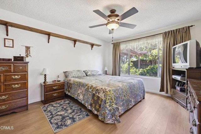 1093 Hickory View Cir, Camarillo, CA 93012 - bedroom featuring light wood finished floors, a textured ceiling, baseboards, and ceiling fan