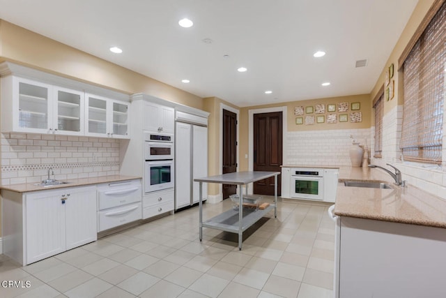 1541 Windshore Way, Oxnard, CA 93035 - kitchen featuring paneled built in fridge, a sink, backsplash, double oven, and white cabinets