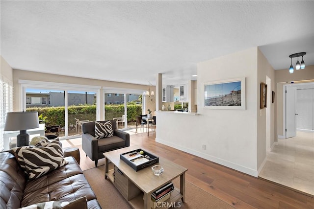 21703 Ocean Vista Dr Unit 102, Laguna Beach, CA 92651 - living area with baseboards, wood-type flooring, a chandelier, and a textured ceiling