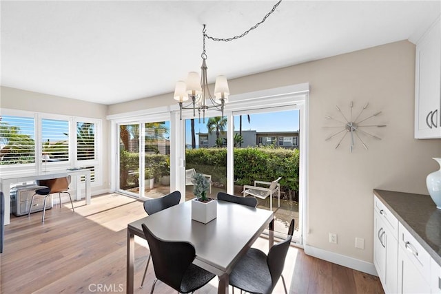 21703 Ocean Vista Dr Unit 102, Laguna Beach, CA 92651 - dining room featuring a chandelier, light wood finished floors, plenty of natural light, and baseboards