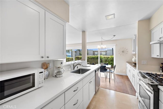 21703 Ocean Vista Dr Unit 102, Laguna Beach, CA 92651 - kitchen featuring appliances with stainless steel finishes, a sink, white cabinets, a chandelier, and light countertops