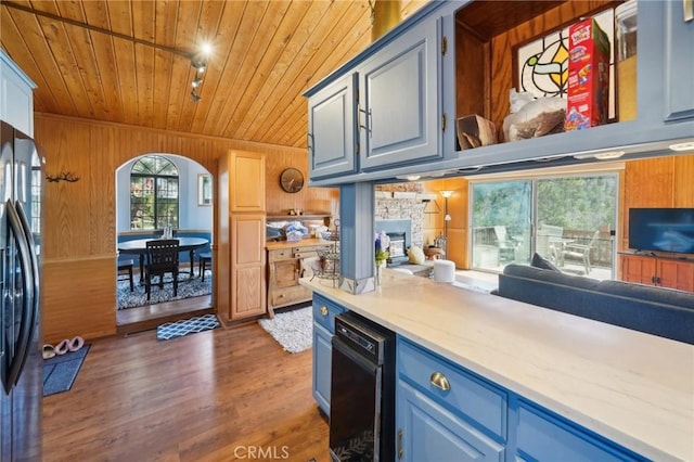1179 Ridge Rd, Fawnskin, CA 92333 - kitchen with wood ceiling, freestanding refrigerator, arched walkways, wood walls, and blue cabinets