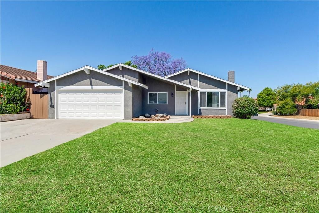 11684 Cielo Ln, Loma Linda, CA 92354 - view of front of home with an attached garage, a front yard, concrete driveway, and stucco siding