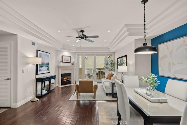 12044 Hoffman St Unit 204, Studio City, CA 91604 - living room with a tray ceiling, dark wood-style flooring, ceiling fan, and a lit fireplace