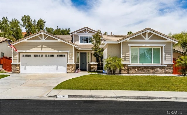 32748 Stonefield Ln, Temecula, CA 92592 - craftsman house featuring stone siding, an attached garage, concrete driveway, a front yard, and a tiled roof
