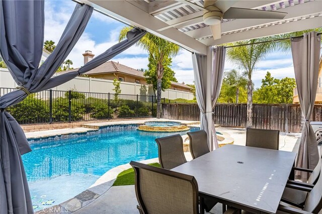 32748 Stonefield Ln, Temecula, CA 92592 - view of swimming pool with ceiling fan, a pool with connected hot tub, a fenced backyard, and outdoor dining space