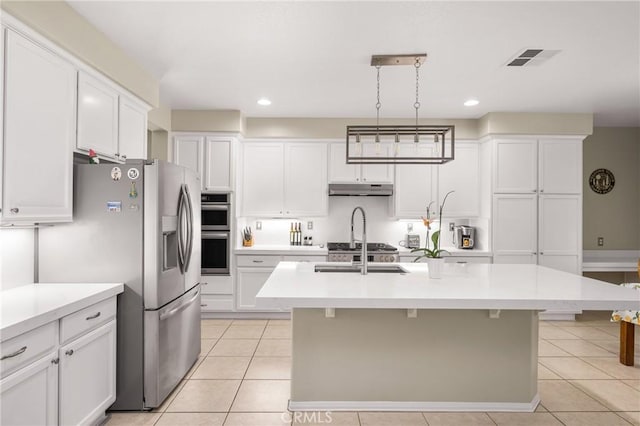 32748 Stonefield Ln, Temecula, CA 92592 - kitchen with stainless steel appliances, under cabinet range hood, light countertops, white cabinets, and light tile patterned floors