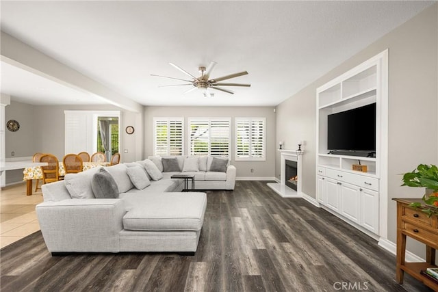 32748 Stonefield Ln, Temecula, CA 92592 - living area featuring ceiling fan, dark wood-type flooring, a lit fireplace, and baseboards