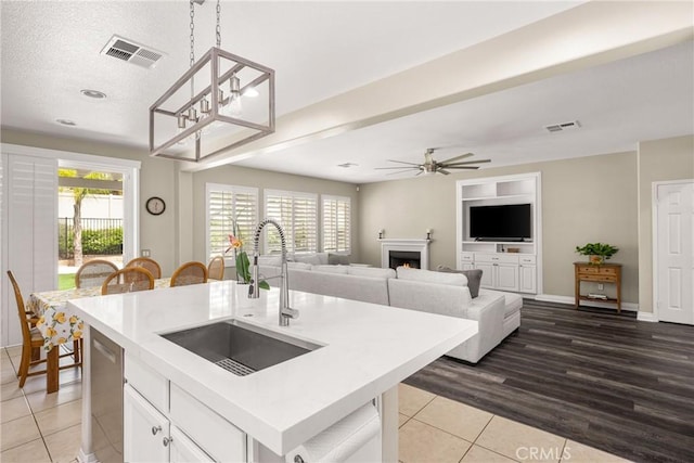 32748 Stonefield Ln, Temecula, CA 92592 - kitchen with a sink, tile patterned flooring, hanging light fixtures, a kitchen island with sink, and light countertops
