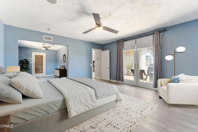 bedroom with access to outside, french doors, a textured ceiling, a ceiling fan, and wood finished floors