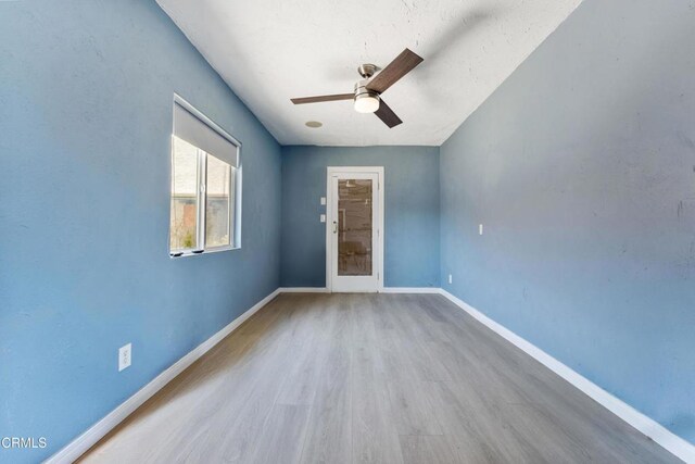 unfurnished room featuring wood finished floors, a ceiling fan, and baseboards