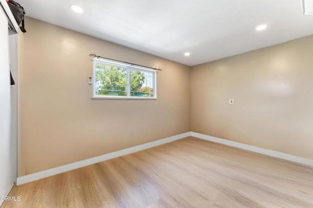 spare room with recessed lighting, wood finished floors, and baseboards