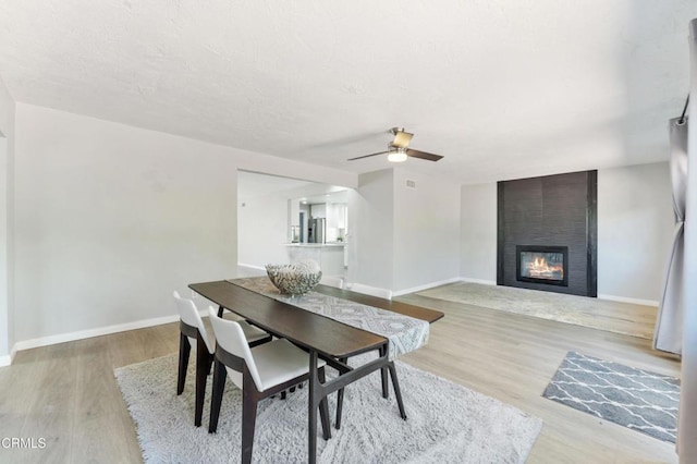 8534 Beverly Dr, San Gabriel, CA 91775 - dining space with a large fireplace, ceiling fan, wood finished floors, and a textured ceiling