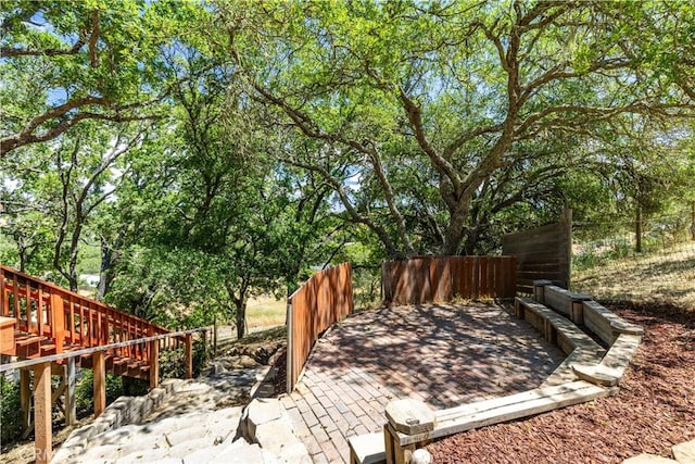 view of patio / terrace featuring fence and stairs