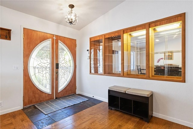 entrance foyer featuring baseboards, a chandelier, and wood finished floors