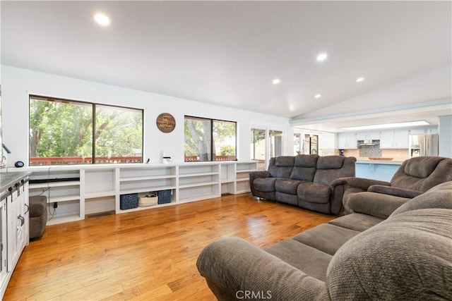 living area featuring light wood-type flooring, recessed lighting, and vaulted ceiling