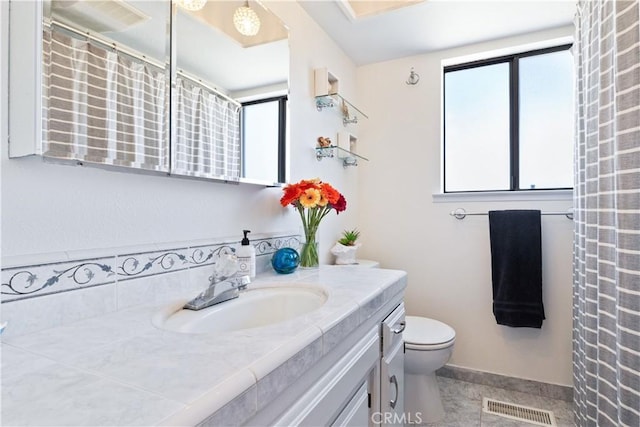 bathroom featuring vanity, toilet, baseboards, and curtained shower
