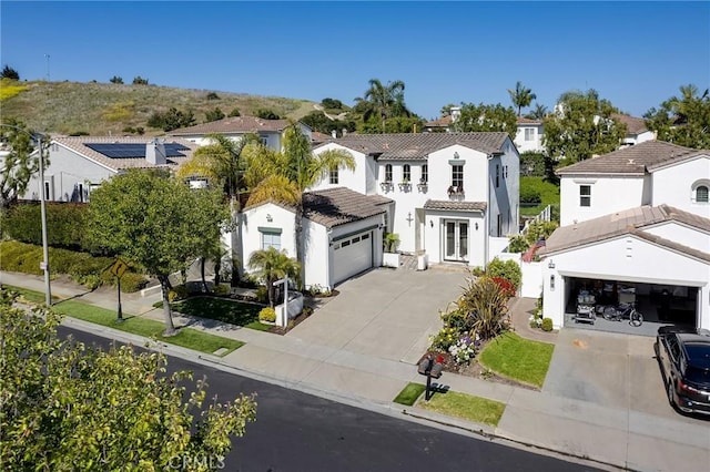 53 Via Palacio, San Clemente, CA 92673 - mediterranean / spanish home featuring driveway, stucco siding, a garage, a tiled roof, and a residential view