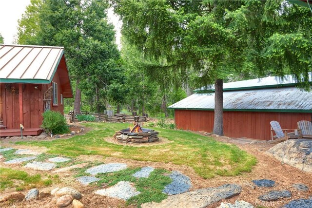 7072 Cranes Nest Rd, Mariposa, CA 95338 - view of grassy yard with a fire pit and an outbuilding