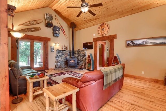 7072 Cranes Nest Rd, Mariposa, CA 95338 - living area featuring a wood stove, light wood-style flooring, ceiling fan, wooden ceiling, and baseboards