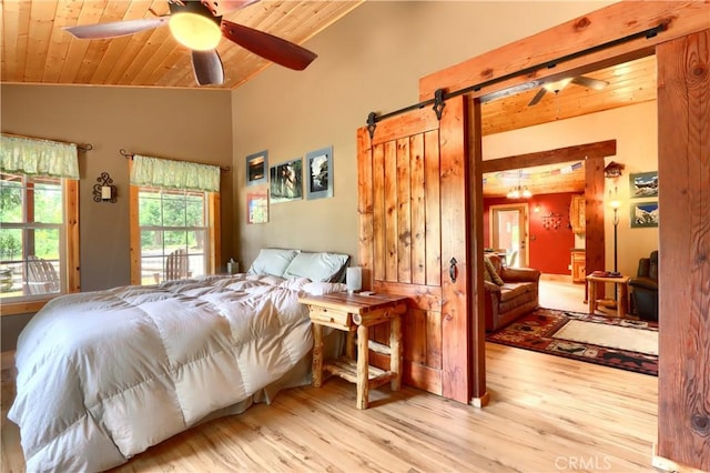7072 Cranes Nest Rd, Mariposa, CA 95338 - bedroom with wooden ceiling, vaulted ceiling, a barn door, and wood finished floors