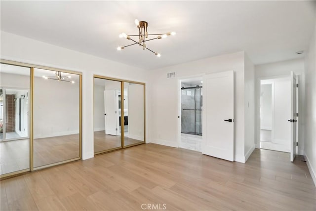 8064 Crosnoe Ave, Panorama City, CA 91402 - unfurnished bedroom featuring a chandelier, two closets, light wood-type flooring, and baseboards