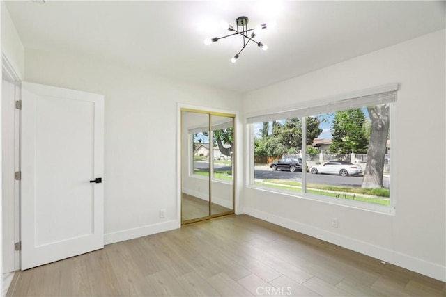 8064 Crosnoe Ave, Panorama City, CA 91402 - unfurnished bedroom featuring a chandelier, wood finished floors, baseboards, and a closet