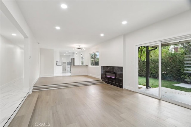 8064 Crosnoe Ave, Panorama City, CA 91402 - unfurnished living room featuring a tiled fireplace, baseboards, recessed lighting, and light wood-style flooring