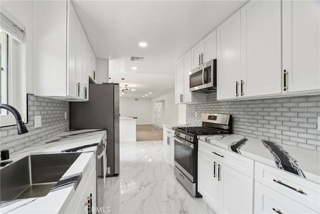 8064 Crosnoe Ave, Panorama City, CA 91402 - kitchen featuring appliances with stainless steel finishes, a sink, recessed lighting, white cabinets, and decorative backsplash