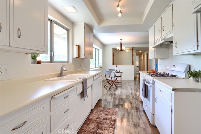 3820 Pinecrest Dr, Mariposa, CA 95338 - kitchen with white appliances, under cabinet range hood, a sink, white cabinetry, and wood finished floors