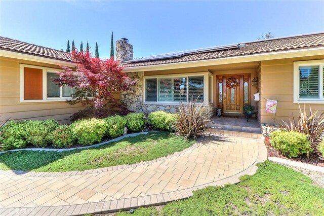161 W Loretto Ct, Claremont, CA 91711 - view of exterior entry featuring a chimney and roof mounted solar panels