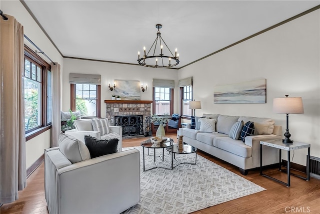 4775 Somerset Dr, Riverside, CA 92507 - living area featuring plenty of natural light, wood finished floors, a chandelier, a fireplace, and ornamental molding