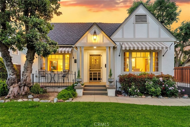 4775 Somerset Dr, Riverside, CA 92507 - tudor house with a shingled roof, a yard, stucco siding, and a porch