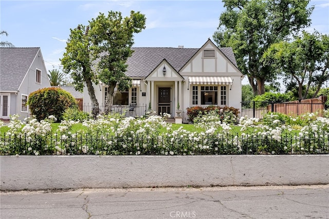 4775 Somerset Dr, Riverside, CA 92507 - tudor-style house featuring fence, a shingled roof, and stucco siding