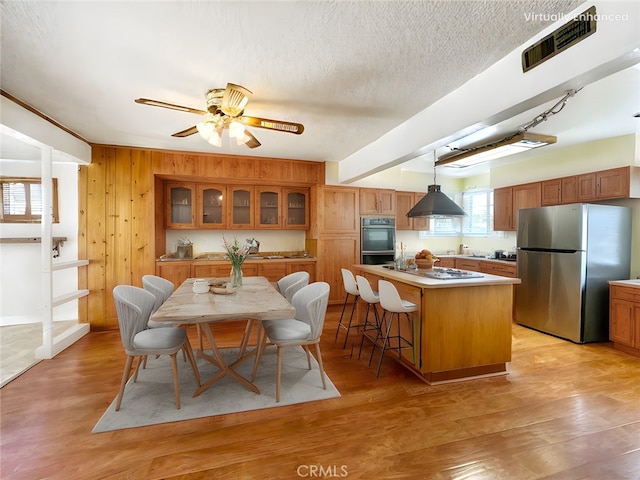817 W Heber St, Glendora, CA 91741 - kitchen featuring freestanding refrigerator, white cooktop, brown cabinetry, a center island, and glass insert cabinets