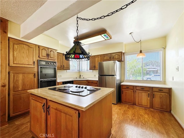 817 W Heber St, Glendora, CA 91741 - kitchen with freestanding refrigerator, electric cooktop, brown cabinetry, light countertops, and a center island