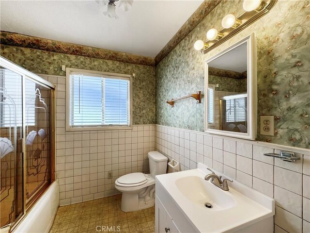 817 W Heber St, Glendora, CA 91741 - full bath with wallpapered walls, combined bath / shower with glass door, wainscoting, tile walls, and vanity